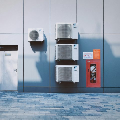 Outdoor AC condenser units mounted on a building wall