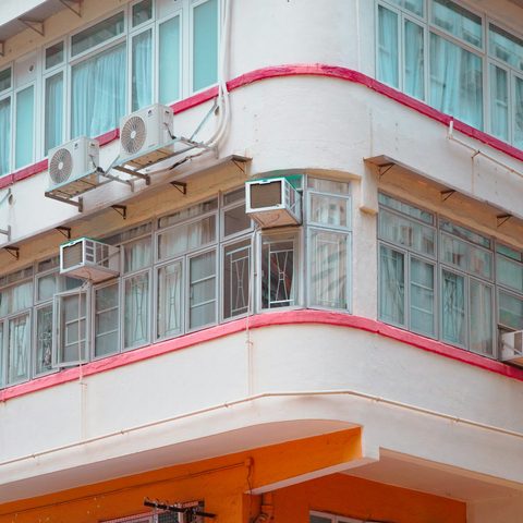 Window AC units on the corner of a white apartment building
